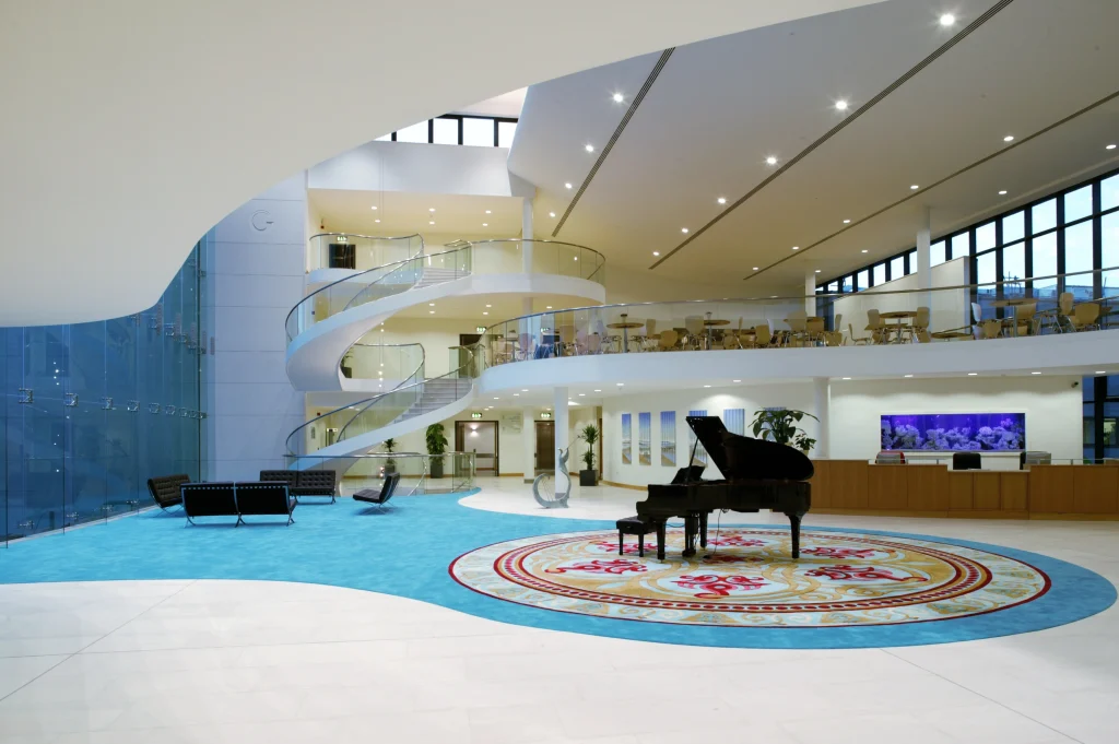 Bright, welcoming atrium at Galway Clinic, showing the spiral staircase, piano and reception desk